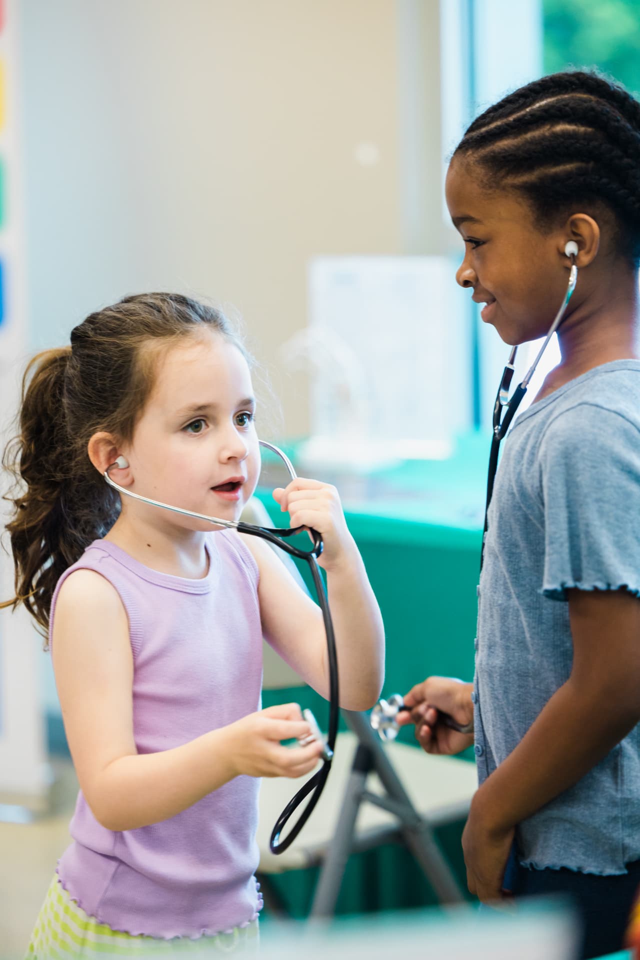 Two children trying stethoscopes at a hands-on health station