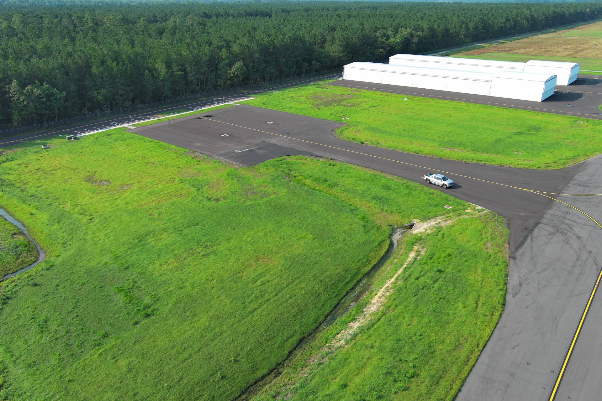 Aerial view of the graded hangar development pad and taxilane at Albert J. Ellis Airport