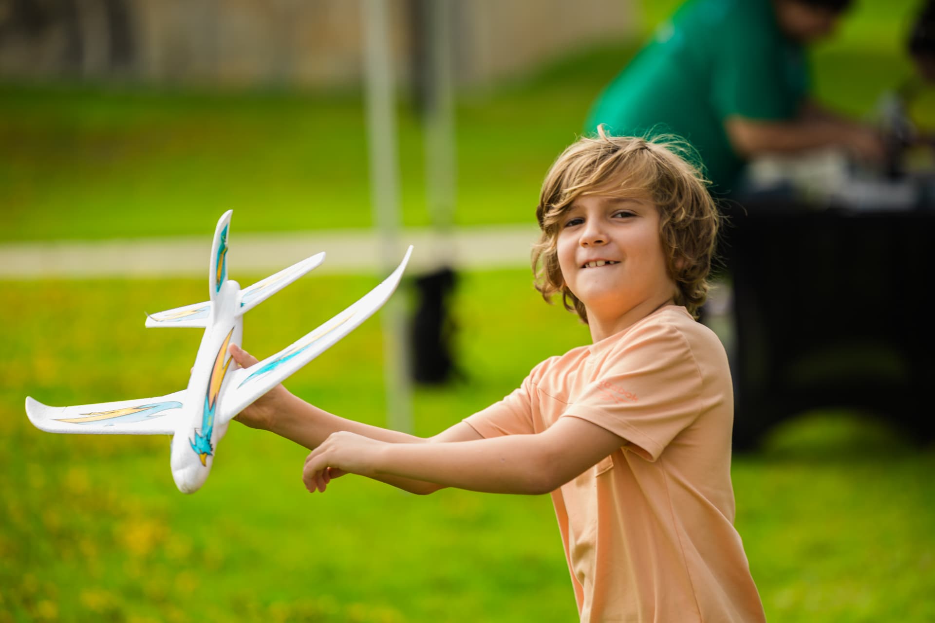 A boy launching a foam glider at a community science event