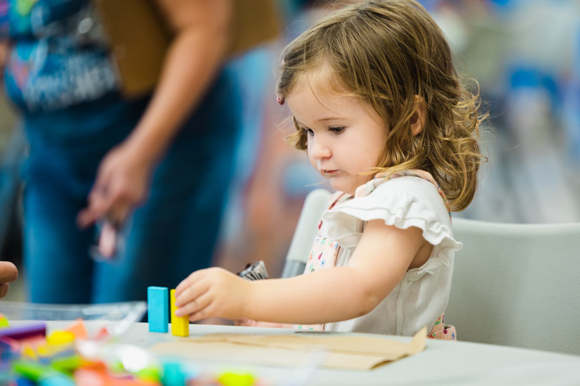 A toddler stacking blocks at a hands-on learning activity